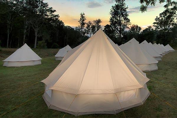 Tents set up for corporate event lit up at night